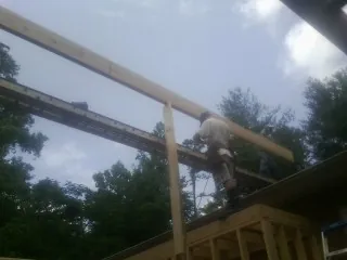 Carpenter setting a ridge beam over a new addition frame — Ice Dam Removal by Roofing Brothers in Cedar Hill