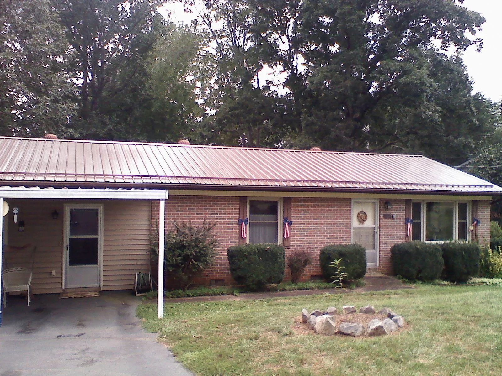 Bronze metal roof and carport on a brick ranch home — Roof Repair work by our crew in Cedar Hill